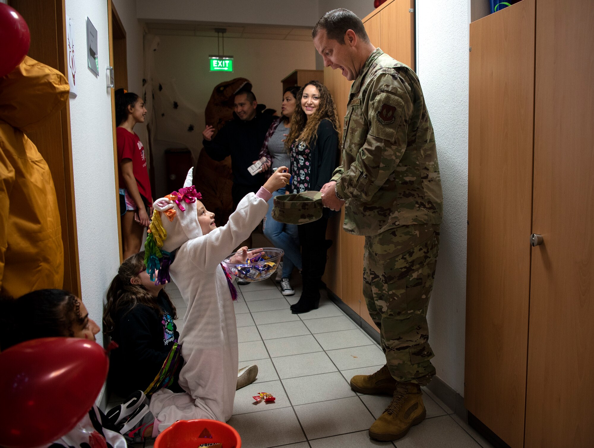 U.S. Air Force Maj. Shawn Schulz, 52nd Comptroller Squadron commander, right, trick-or-treats during a deployed-family event in the Airman and Family Readiness Center at Spangdahlem Air Base, Germany, Oct. 17, 2019. Deployed-family events are a monthly occurrence that provide activities and a meal to families. Base leadership and agencies provide support, services, and resources. (U.S. Air Force photo by Airman 1st Class Valerie Seelye)