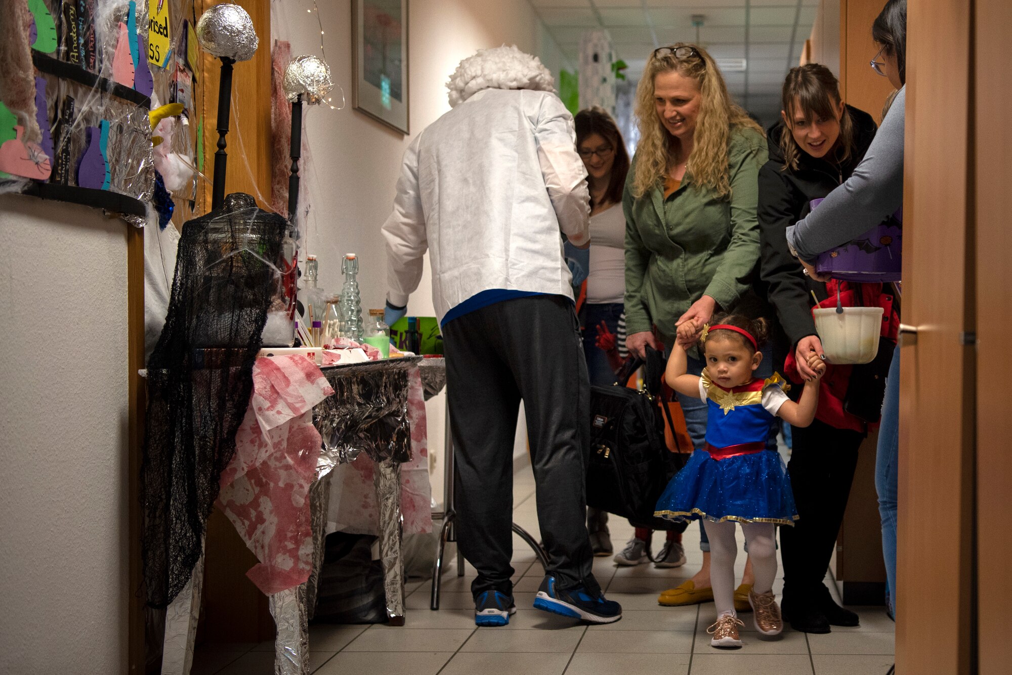 Spangdahlem Air Base families trick-or-treat in the Airman and Family Readiness Center during a deployed-family event at Spangdahlem AB, Germany, Oct. 17, 2019. Volunteers representing different units decorated Halloween-themed doors, dressed up, and handed out candy to deployment-affected families. (U.S. Air Force photo by Airman 1st Class Valerie Seelye)