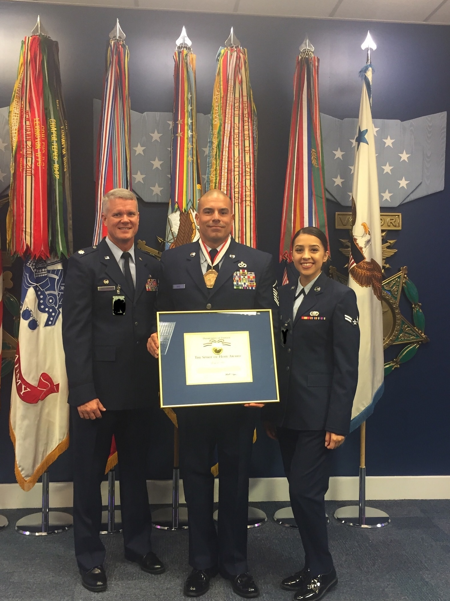 U.S. Air Force Master Sgt. Jorge L. Arce, 86th Aircraft Maintenance Squadron first sergeant, poses for a photo with his daughter, Airman 1st Class Sybella Crespo, 56th Logistics Readiness Squadron, and Lt. Col. Jeffrey Westerman, 86th AMXS commander, after the Bob Hope “Spirit of Hope” award ceremony at the Pentagon, Sept. 27, 2019. (Courtesy photo/Photo edited to black out security badges)