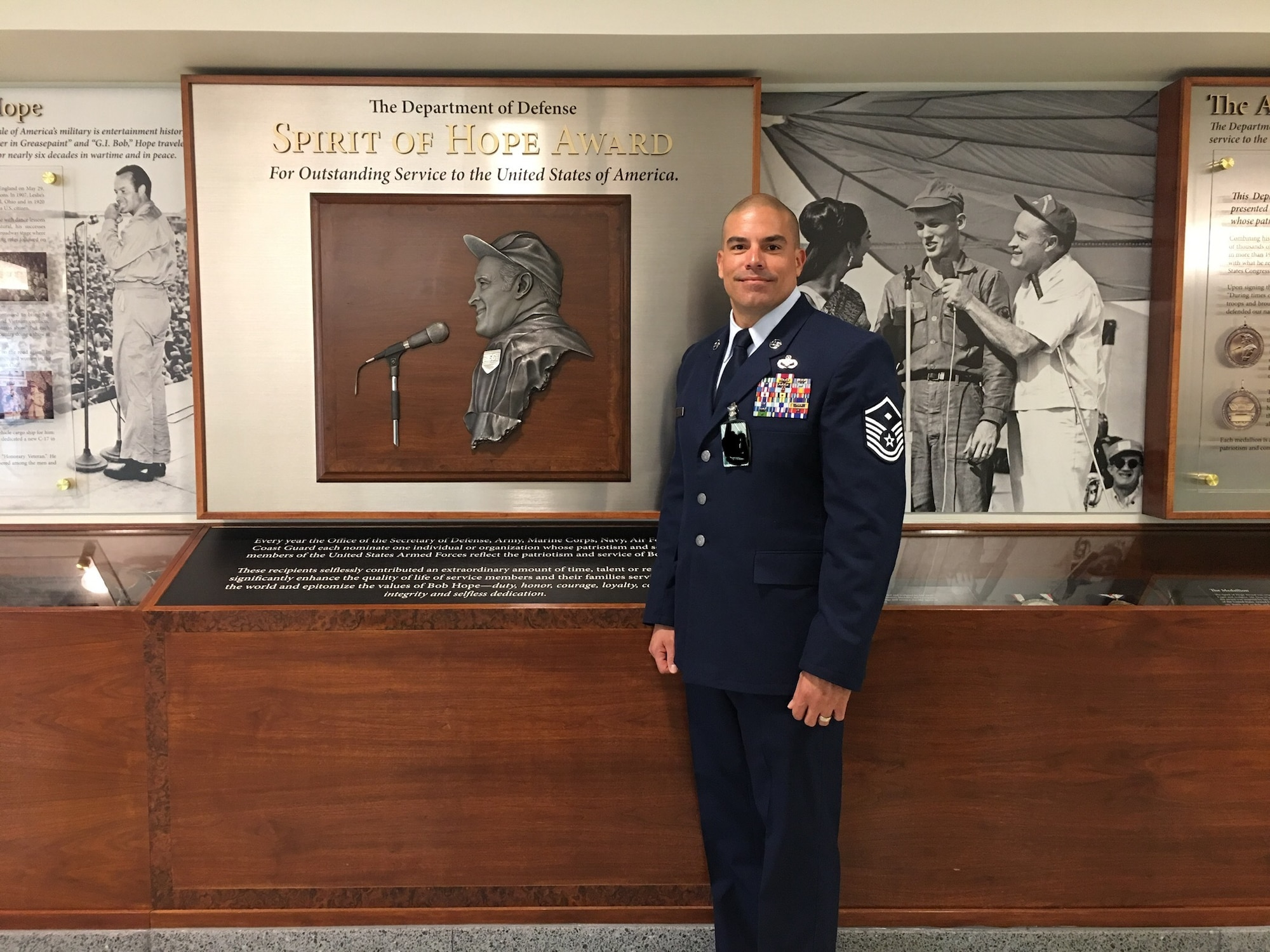 U.S. Air Force Master Sgt. Jorge L. Arce, 86th Aircraft Maintenance Squadron first sergeant, poses for a photo in front of the Bob Hope “Spirit of Hope” award wall at the Pentagon, Sept. 27, 2019. (Courtesy photo/Photo edited to black out security badges)
