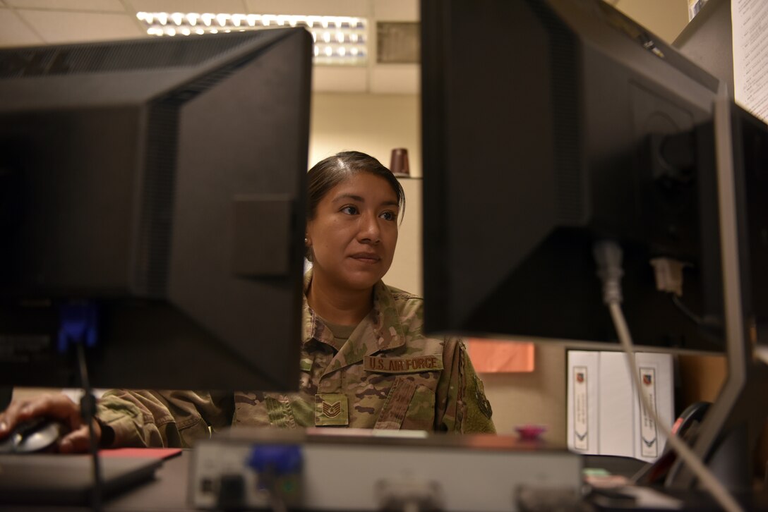 Tech. Sgt. Alejandra Martinez, 379th Air Expeditionary Wing security manager and executive administration non-commissioned officer-in-charge, reviews policies and procedures at her workstation at Al Udeid Air Base, Qatar on Oct. 18, 2019.