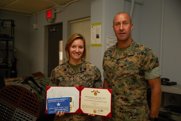 U.S. Marine Staff Sgt. Elissa Pedelty receives $1,000 and a Navy and Marine Corps Achievement Medal for her winning idea in designing an Environmental Control Unit (ECU) duct cover at MakerSpace, Camp Lejeune, North Carolina, on Oct. 16, 2019. MakerSpace facilitates the 2nd Marine Logistics Group Commanding General’s Innovation Challenge, where Marines and Sailors submit innovative ideas to design an interesting culture that explores new ideas to improve policies, procedures or products.  (U.S. Marine Corps photo by Sgt. Ashley Lawson)