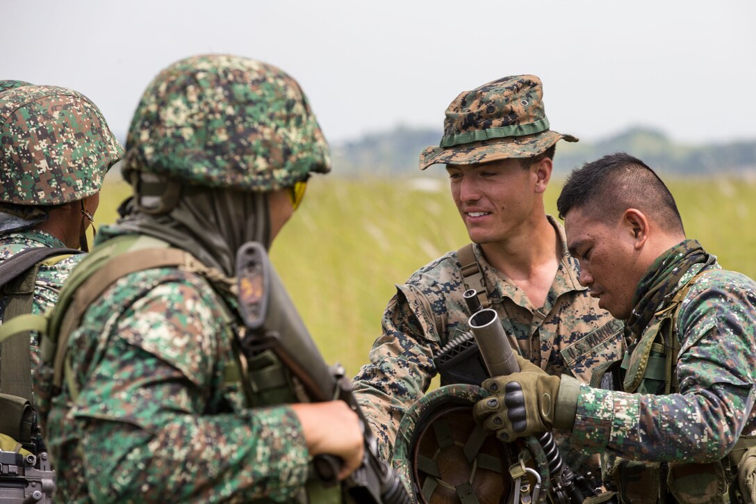 Philippine Marines exchange infantry tactics with U.S. Marine Cpl. Christian Salvaggio prior to a live fire range conducted during KAMANDAG 3 at Colonel Ernesto P. Ravina Air Base, Philippines, Oct. 14.