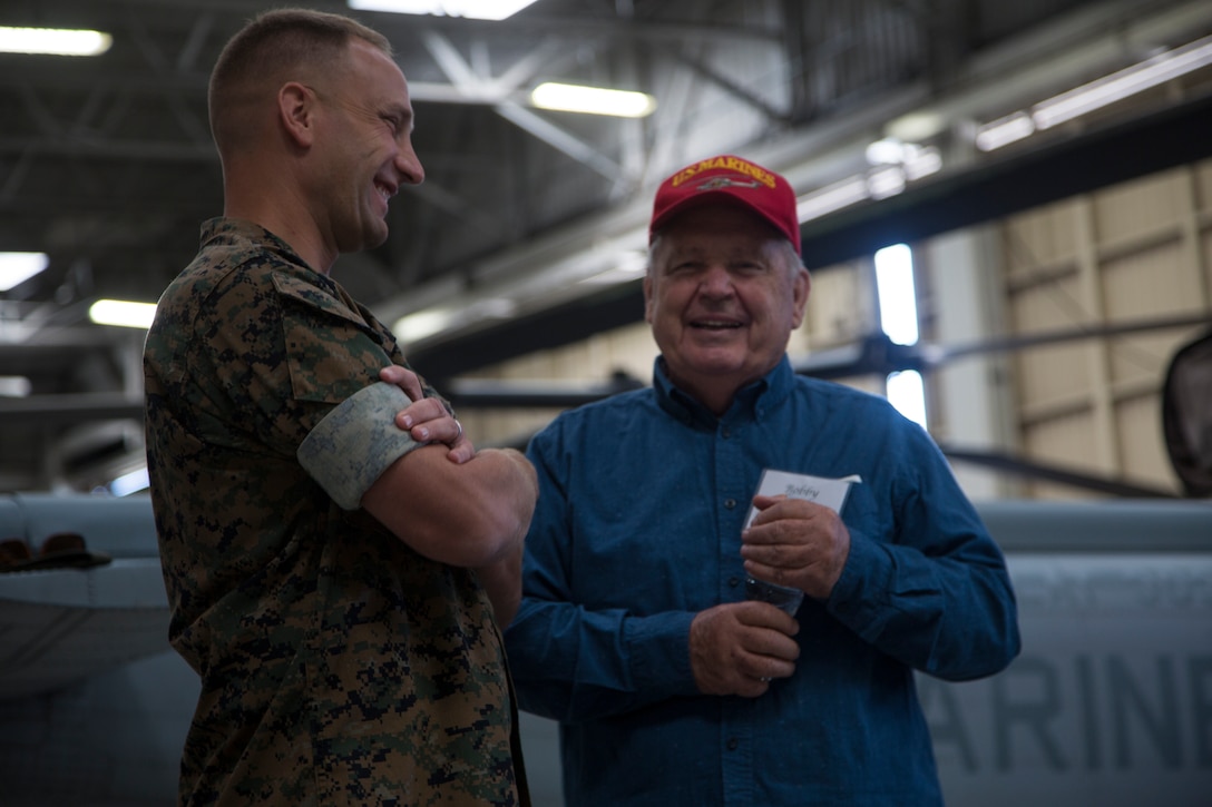 Retired U.S. Marine Corps Capt. Bobby Thatcher discusses his time in the Marine Corps with Lt. Col. William Wallace, commanding officer of Marine Light Attack Helicopter Squadron 303, Marine Aircraft Group 39, 3rd Marine Aircraft Wing, during the Marine Observation Squadron (VMO) 6 reunion on Marine Corps Air Station Camp Pendleton, Calif., Oct. 16, 2019. The VMO-6 reunion gave the veterans an opportunity to see their old stomping grounds and admire how far the aircraft that their generation paved the way for have come. (U.S. Marine Corps photo by Cpl. Levi J. Guerra)