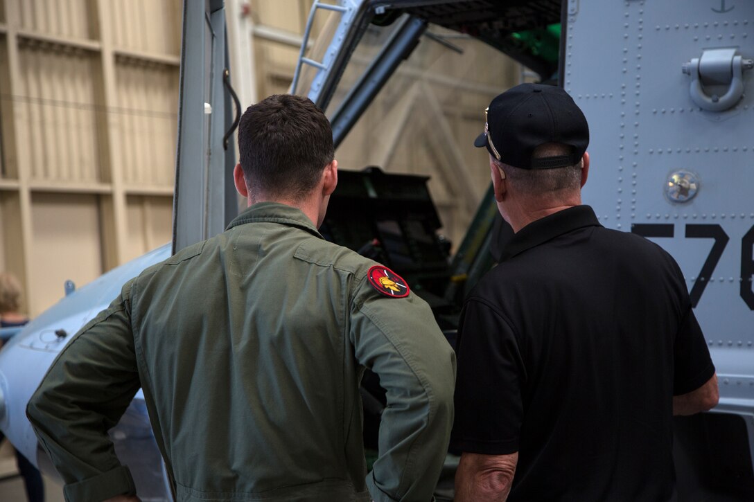 U.S. Marine Corps Capt. Joseph Deignan, adjutant for Marine Light Attack Helicopter Squadron 303, Marine Aircraft Group 39, 3rd Marine Aircraft Wing, discusses the new upgrades to the UH-1Y Venom with retired Marine Corps Cpl. Dave Schoenherr during the Marine Observation Squadron (VMO) 6 reunion on Marine Corps Air Station Camp Pendleton, Calif., Oct. 16, 2019. The VMO-6 reunion gave the veterans an opportunity to see their old stomping grounds and admire how far the aircraft that their generation paved the way for have come. (U.S. Marine Corps photo by Cpl. Levi J. Guerra)