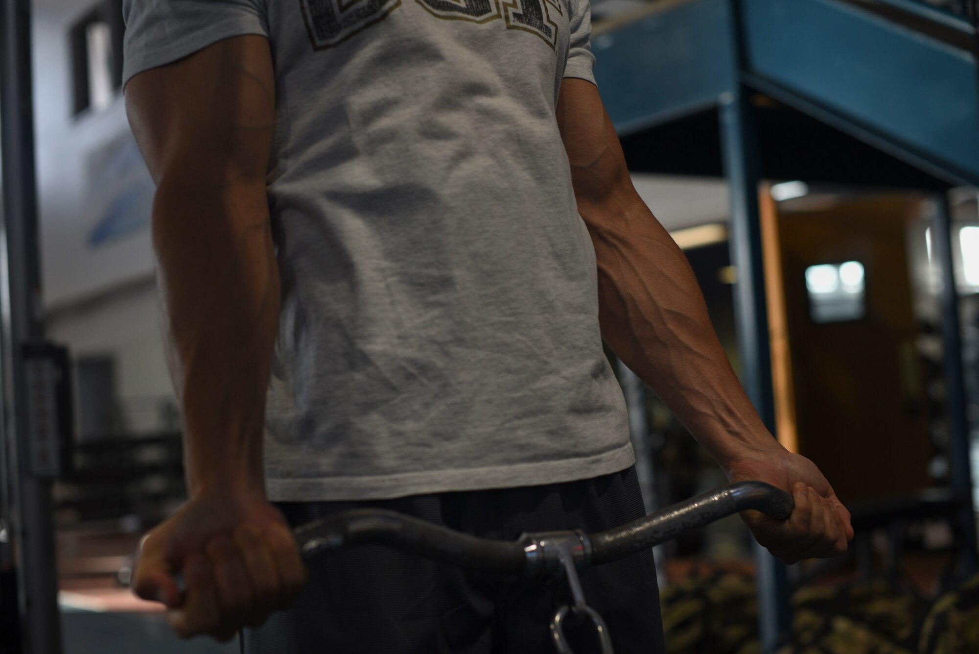 Major Richard Bottinelli, 90th Force Support Squadron operations officer, cable curls at the Independence Hall Fitness Center on F.E. Warren Air Force Base, Wyo., July 18, 2019. In the months leading to the competition, his coach would change his workout routines to help even out muscle groups. (U.S. Air Force photo by Staff Sgt. Ashley N. Sokolov)