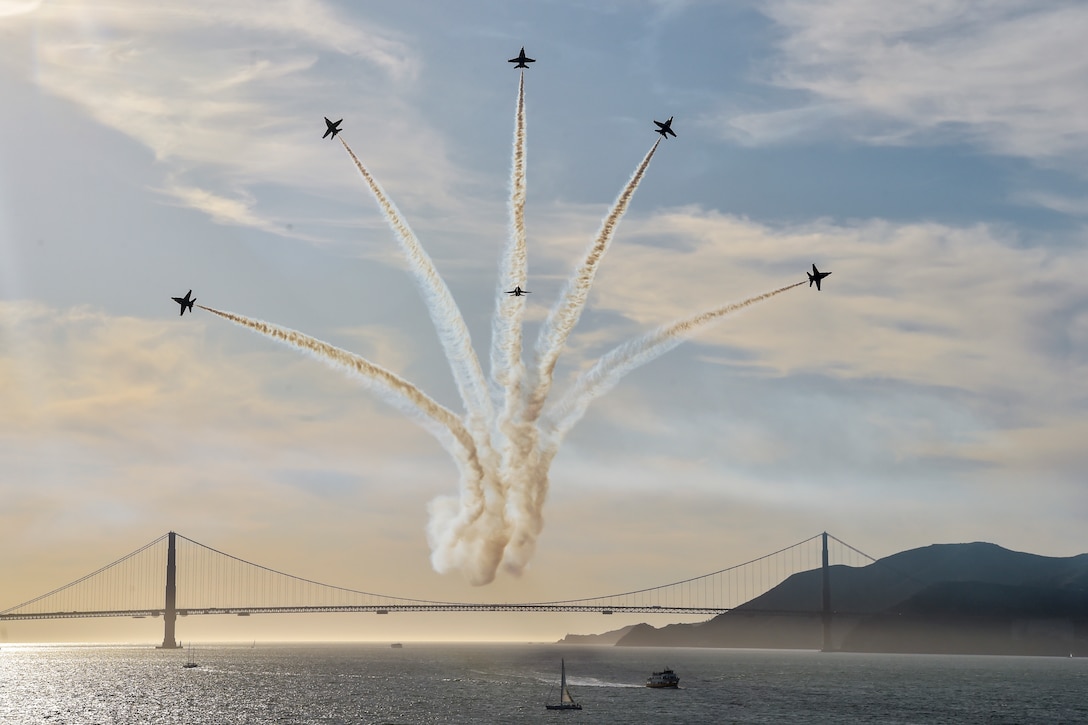 Six jets fly fan out in a formation over the Golden Gate bridge.