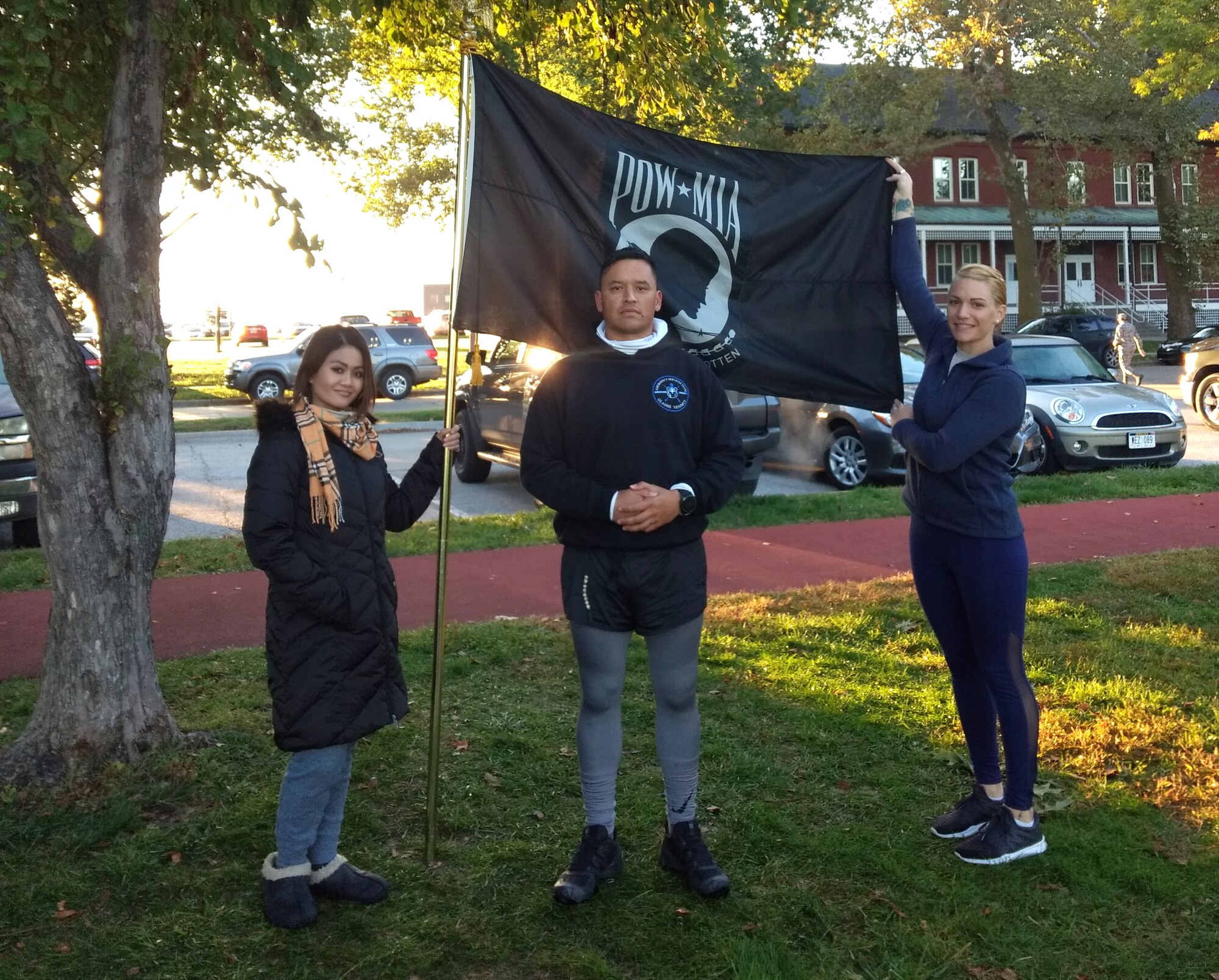 runners pose with POW/MIA flag after running 24 hours