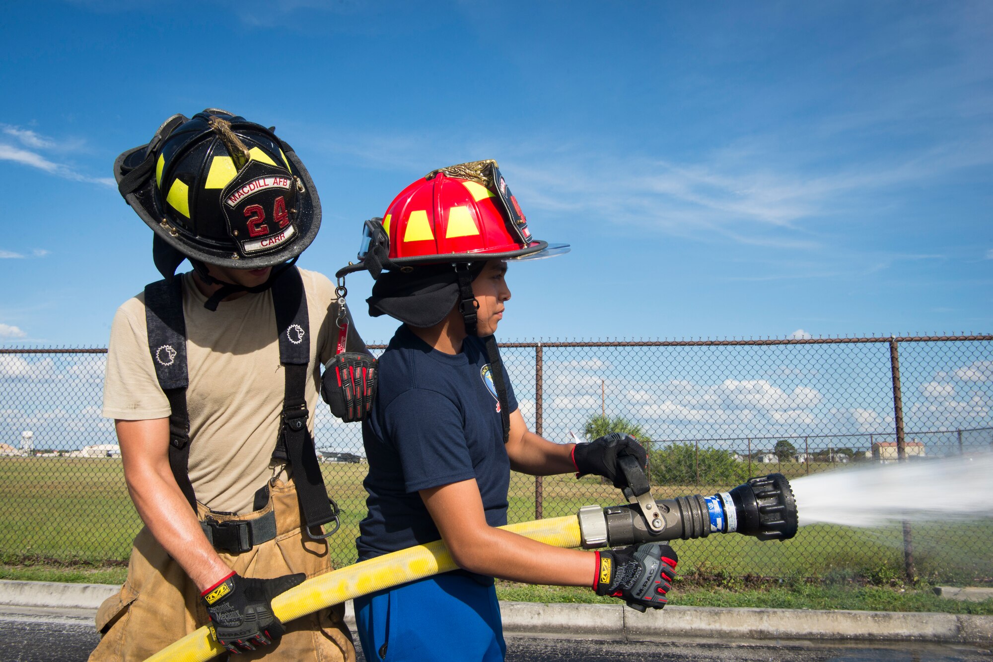 Senior Airman Kenneth Carr, a 6th Civil Engineer Squadron (CES) Fire Emergency Services (FES) Flight firefighter, teaches a student how to operate a fire hose at MacDill Air Force Base, Fla., Oct. 15, 2019.