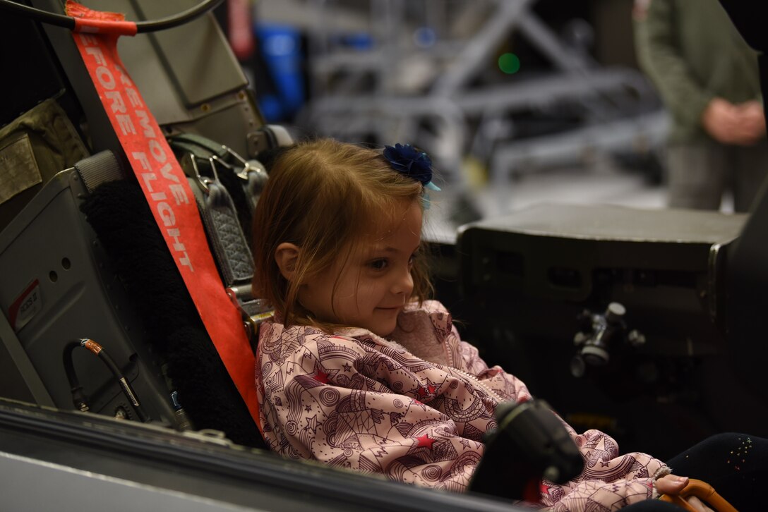 Sarah, with Make-A-Wish Utah, sits in the cockpit of an F-16 trainer at the 388th Fighter Wing. A group of children visited the 388th Fighter Wing where they spent the day learning what it's like to be a pilot. They received flight suits, name tapes, patches, and wings. (U.S. Air Force photo by Micah Garbarino)