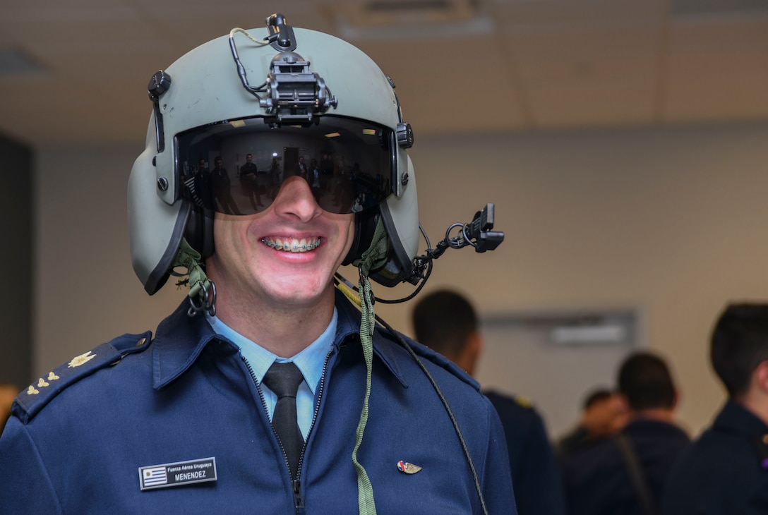 A cadet from the Latin American Cadet Initiative poses for a photo after trying on a HGU-56/P helmet during a 1st Helicopter Squadron tour on Joint Base Andrews, Md., Oct. 16, 2019.