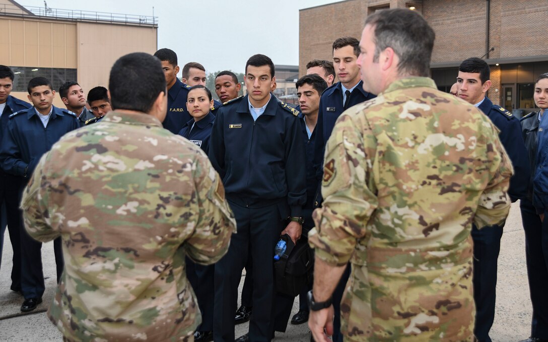 Master Sgt. Jose Velazquez, left, 811th Operations Support Squadrons flight chief, and Tech. Sgt. David Prato, right, 1st Helicopter Squadron UH-1N special missions aviator instructor, explain the capabilities of a UH-1N Iroquois to cadets from the Latin American Cadet Initiative during a 1st Helicopter Squadron tour on Joint Base Andrews, Md., Oct. 16, 2019.