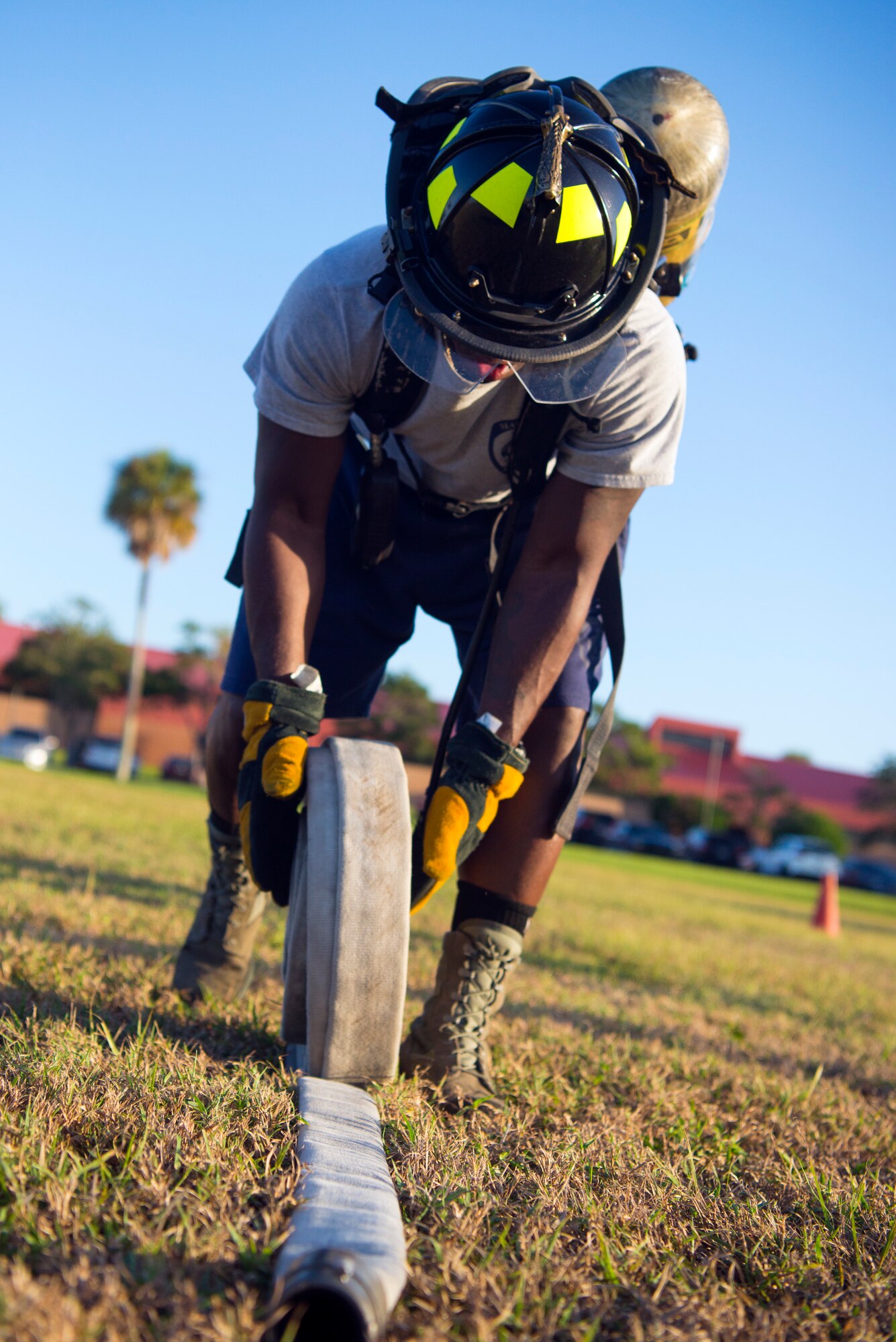U.S. Air Force Staff Sgt. Ashton Holloway, a 6th Civil Engineer Squadron Fire Emergency Services Flight firefighter, rolls a fire hose for a firefighter muster during Fire Prevention Week at MacDill Air Force Base, Fla., Oct. 11, 2019.