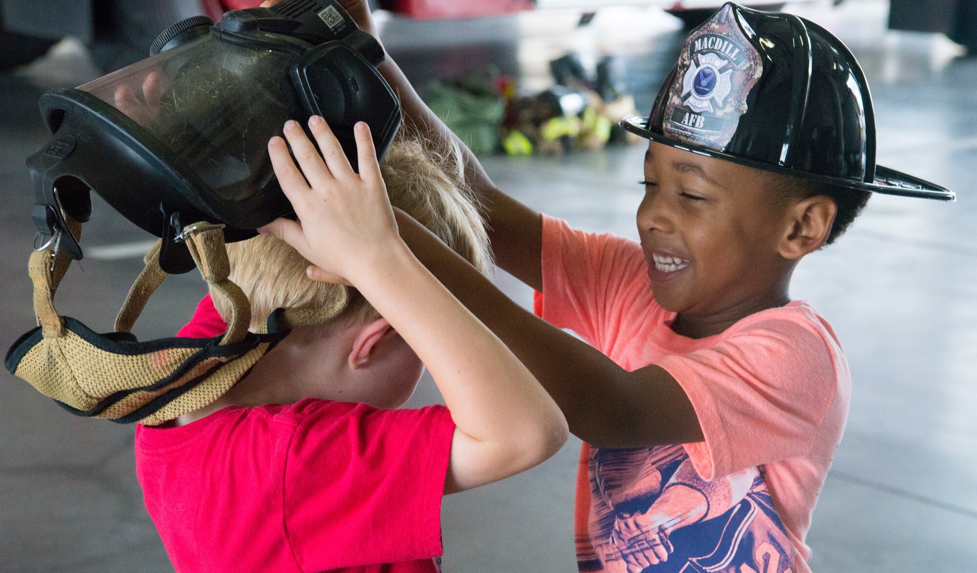 Tinker Elementary students try on helmets at the Crash Fire Station during Fire Prevention Week at MacDill Air Force Base, Fla., Oct. 8, 2019.