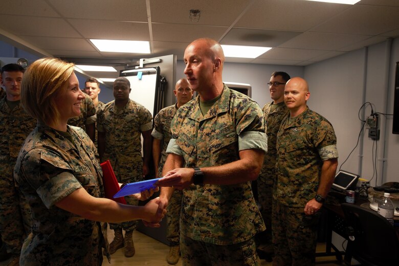 U.S. Marine Staff Sgt. Elissa Pedelty receives $1,000 and a Navy and Marine Corps Achievement Medal for her winning idea in designing an Environmental Control Unit (ECU) duct cover at MakerSpace, Camp Lejeune, North Carolina, on Oct. 16, 2019. MakerSpace facilitates the 2nd Marine Logistics Group Commanding General’s Innovation Challenge, where Marines and Sailors submit innovative ideas to design an interesting culture that explores new ideas to improve policies, procedures or products.  (U.S. Marine Corps photo by Sgt. Ashley Lawson)