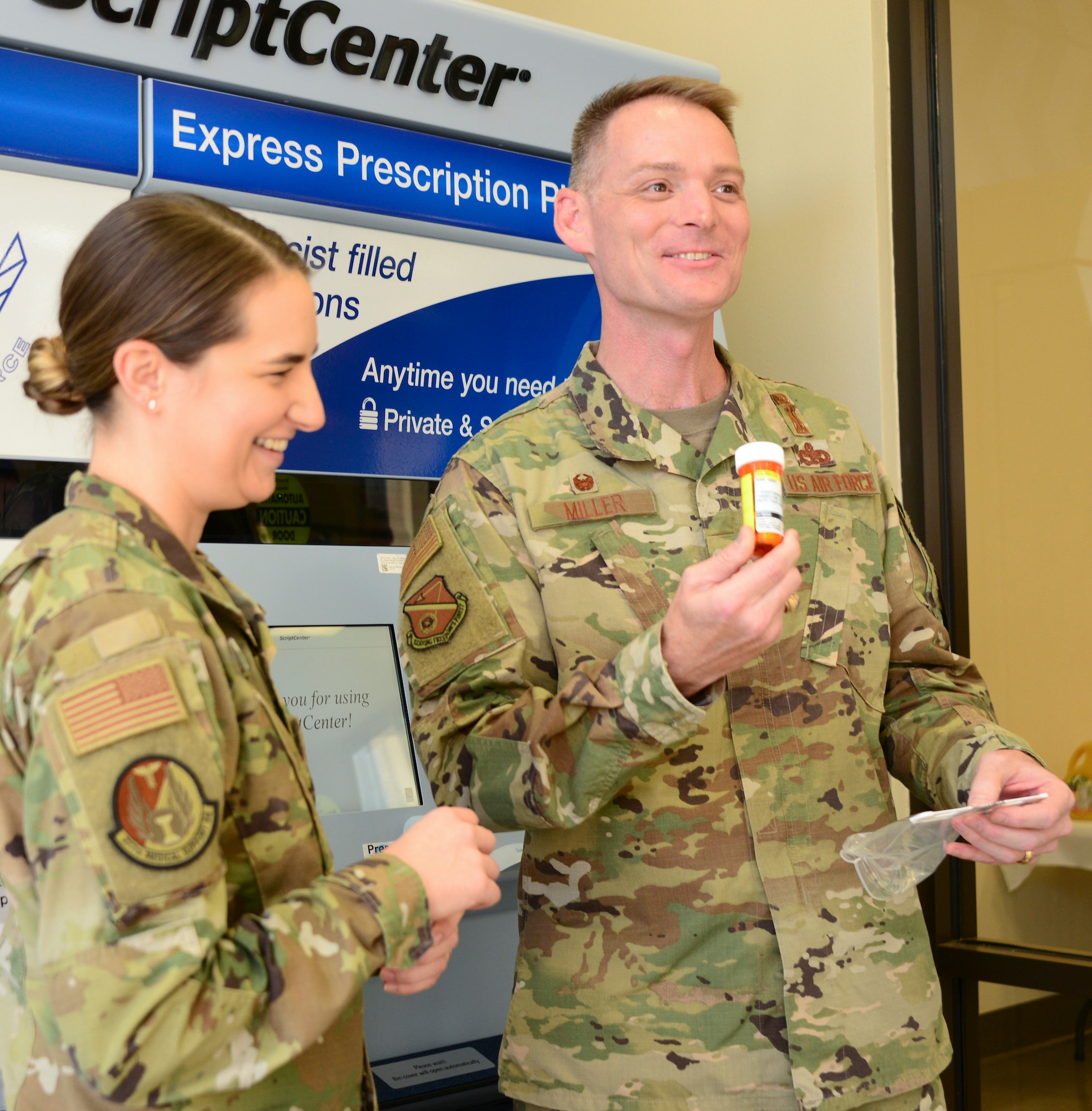 Col. David S. Miller, 377th Air Base Wing installation commander speaks following a demonstration from Master Sgt. Raechael Evans, 377th Medical Group pharmacy flight chief, on stocking the new ScriptCenter kiosk at the Base Exchange Oct. 16. Roughly 800 patients visit the BX Pharmacy on high volume days. The ScriptCenter can re-direct 350 of those patients, increasing access to care and time away from the duty section for active duty service members. (U.S. Air Force photo by Jessie Perkins)