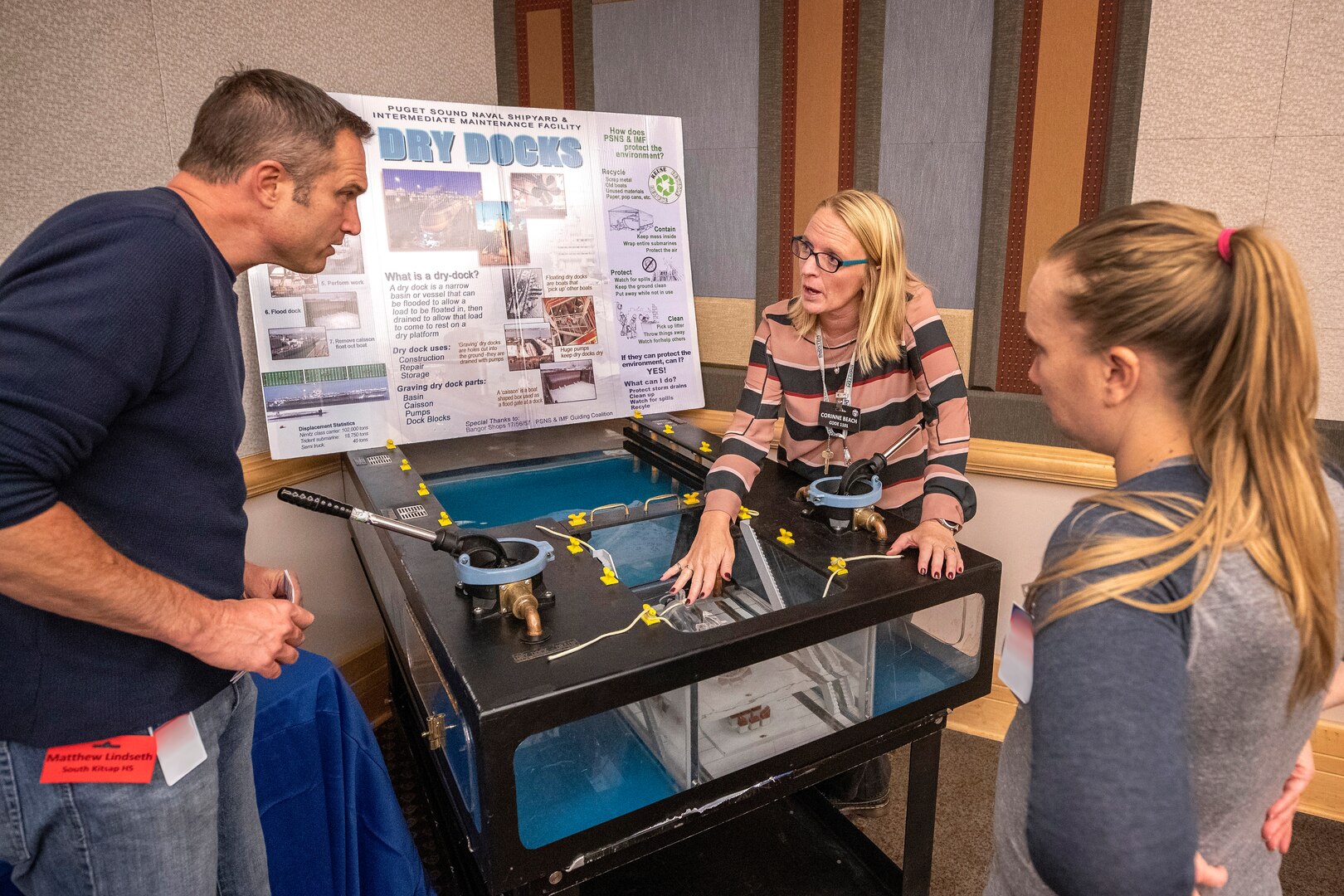 Corinne Beach, a STEM coordinator with Puget Sound Naval Shipyard & Intermediate Maintenance Facility uses a model to demonstrate a dry-dock pump for educators from South Kitsap High School in Port Orchard, Wash.