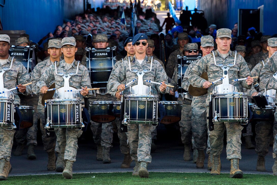 A large band marches through a tunnel.