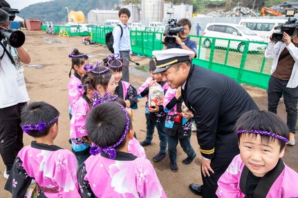 Lt. Saungwon Ko, communications officer of Avenger-class mine countermeasures ship USS Pioneer (MCM 9), speaks with local kindergarteners from Uki city.