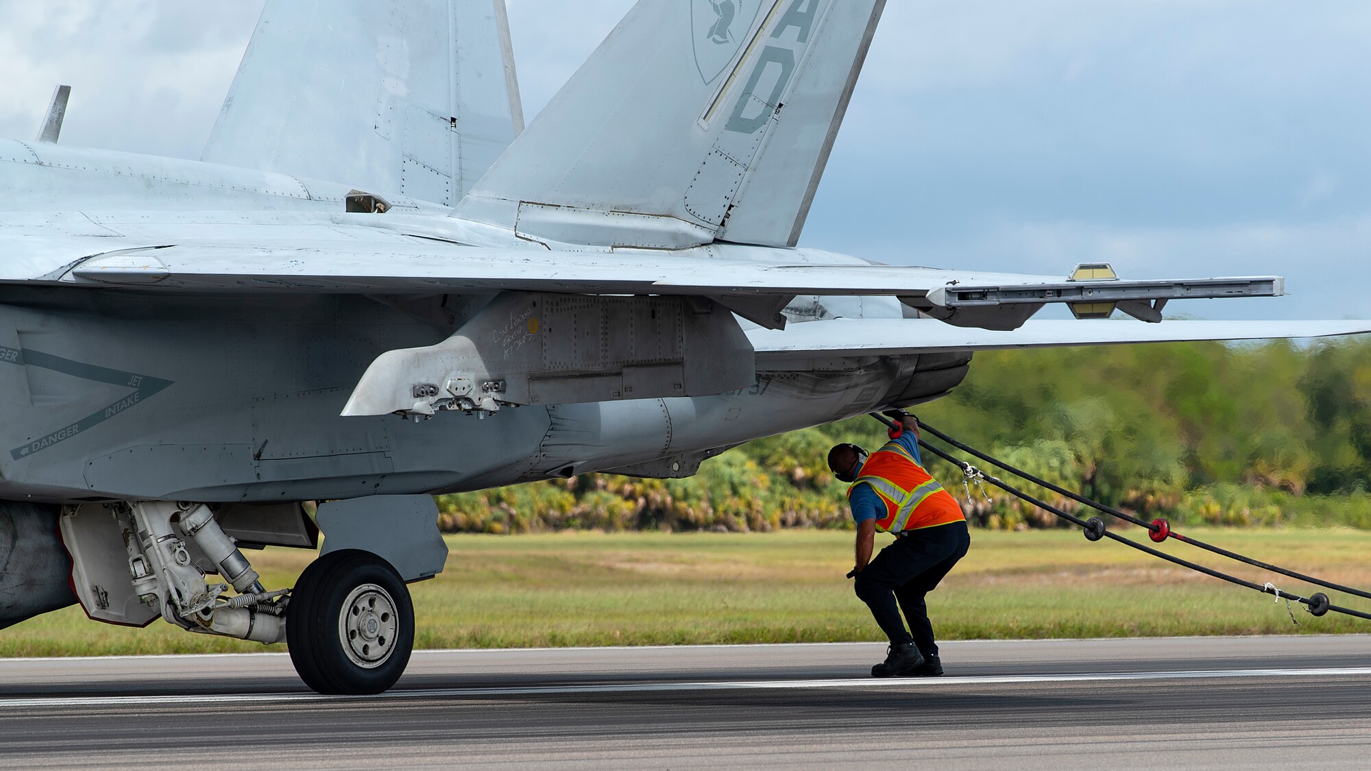 A U.S. Air Force firefighter unhooks the arresting cable from the tailhook of a U.S. Navy Strike Fighter Squadron 106 F/A-18F Super Hornet aircraft after an arrested landing at MacDill Air Force Base, Fla., Oct 16, 2019. Arrested landings allow pilots to achieve rapid deceleration when landing aboard an aircraft carrier by attaching a tailhook to a cable, which absorbs the energy of the aircraft.