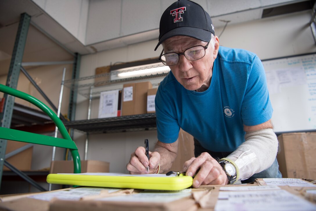 A man records data on a clipboard.