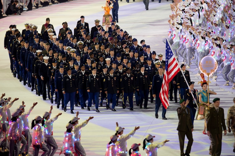 A large group of military athletes march in a parade.