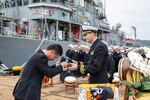 UKI, Japan (October 18, 2019) Commanding officer of Avenger-class mine countermeasures ship USS Pioneer (MCM 9), Lt. Cmdr. Bobby Wayland, gives a command ball cap to the mayor of Uki city, Kenshi Morita. Pioneer, part of Mine Countermeasures Squadron 7, is operating in the 7th Fleet area of operations to enhance interoperability with partners and serve as a ready-response platform for contingency operations.