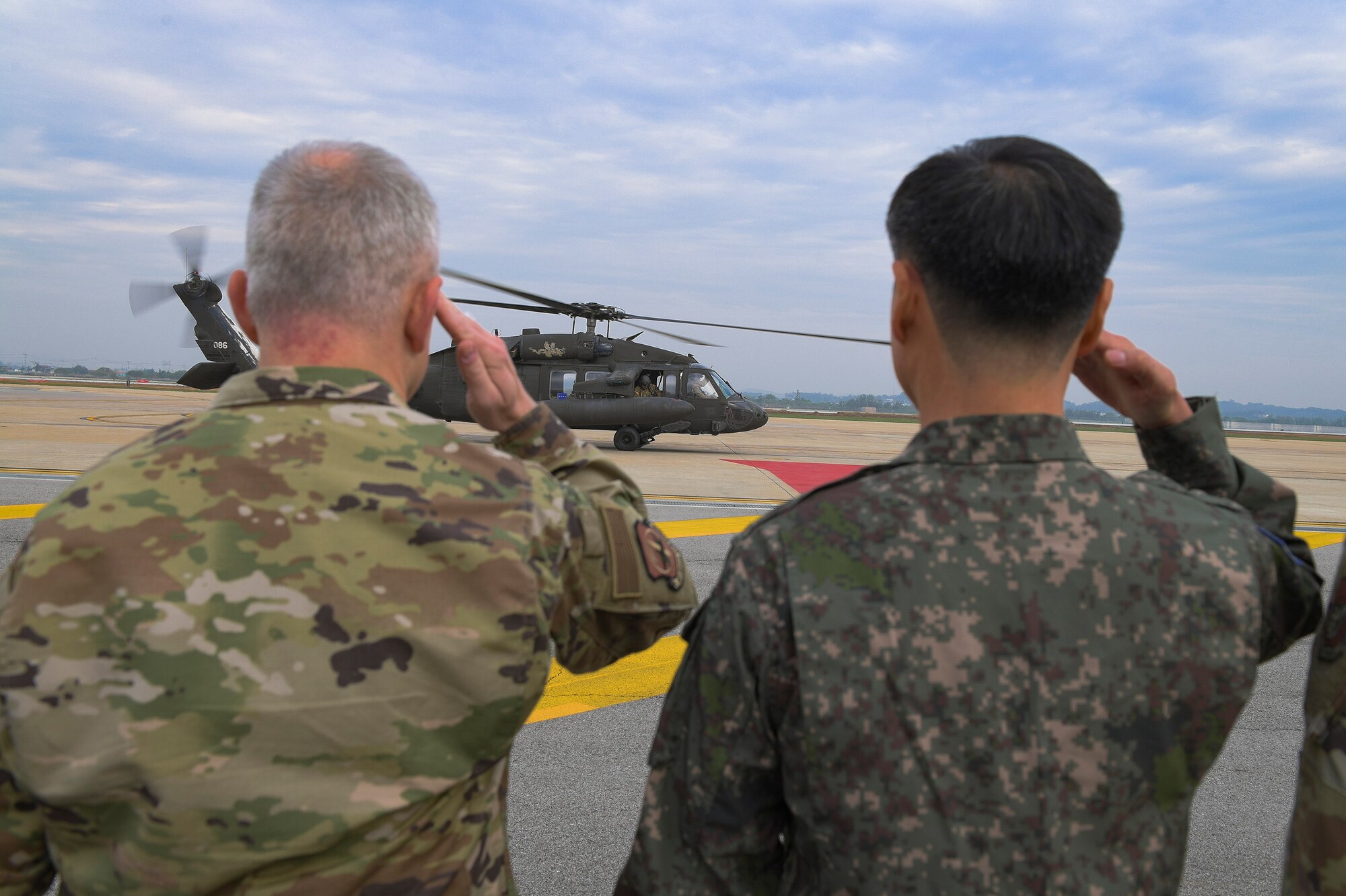 U.S. Air Force and Republic of Korea air force members salute a UH-60 Blackhawk helicopter upon the arrival of Gen. CQ Brown, Jr., Pacific Air Forces commander, Oct. 17, 2019, at Osan Air Base, ROK. While gaining an in-depth exposure of the installation’s unique mission, Brown used the visit as an opportunity to explain Pacific Air Forces’ priorities and how vital Team Osan is in contributing to the Indo-Pacific region’s security and stability. (U.S. Air Force photo by Staff Sgt. Greg Nash)
