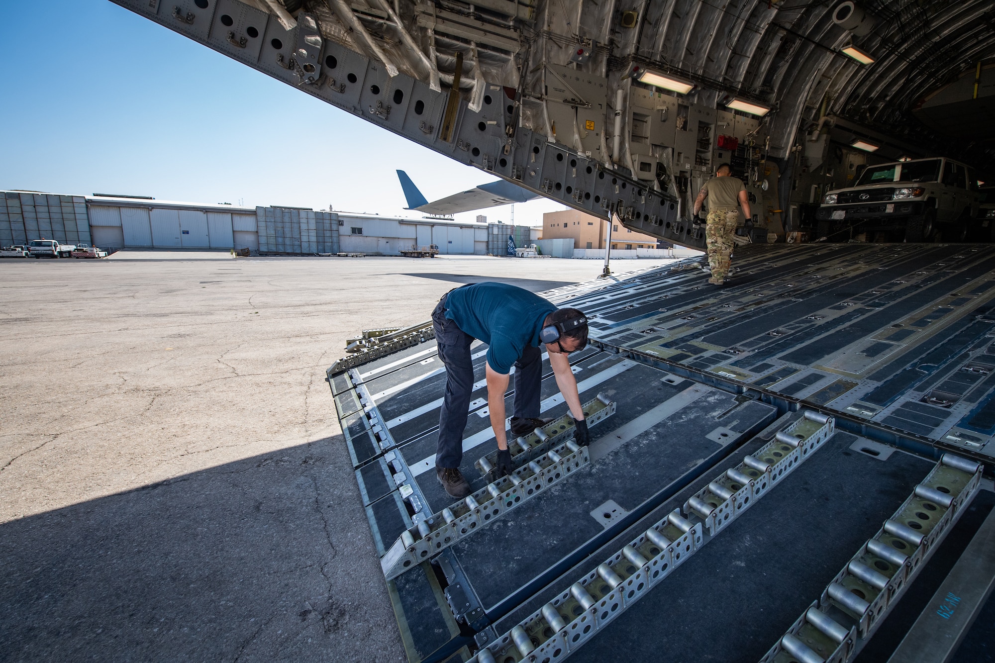 Staff Sgt. Tony Bellow, NCO-in-charge of Cargo Operations, Jordan Port, 387th Air Expeditionary Squadron, removes rollers from the cargo ramp of a U.S. Air Force C-17 Globemaster III before unloading vehicles in Jordan, Oct. 14, 2019.