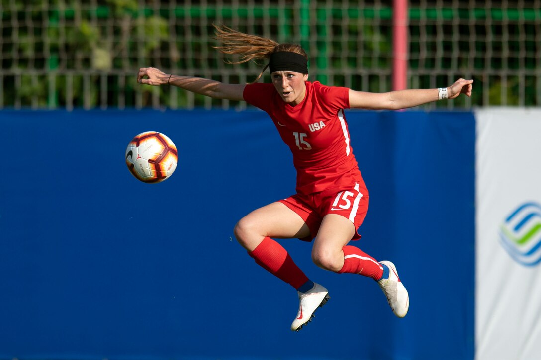 An Air Force soccer player jumps in the air to block a ball.