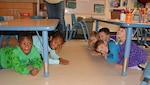 Children practice earthquake drill