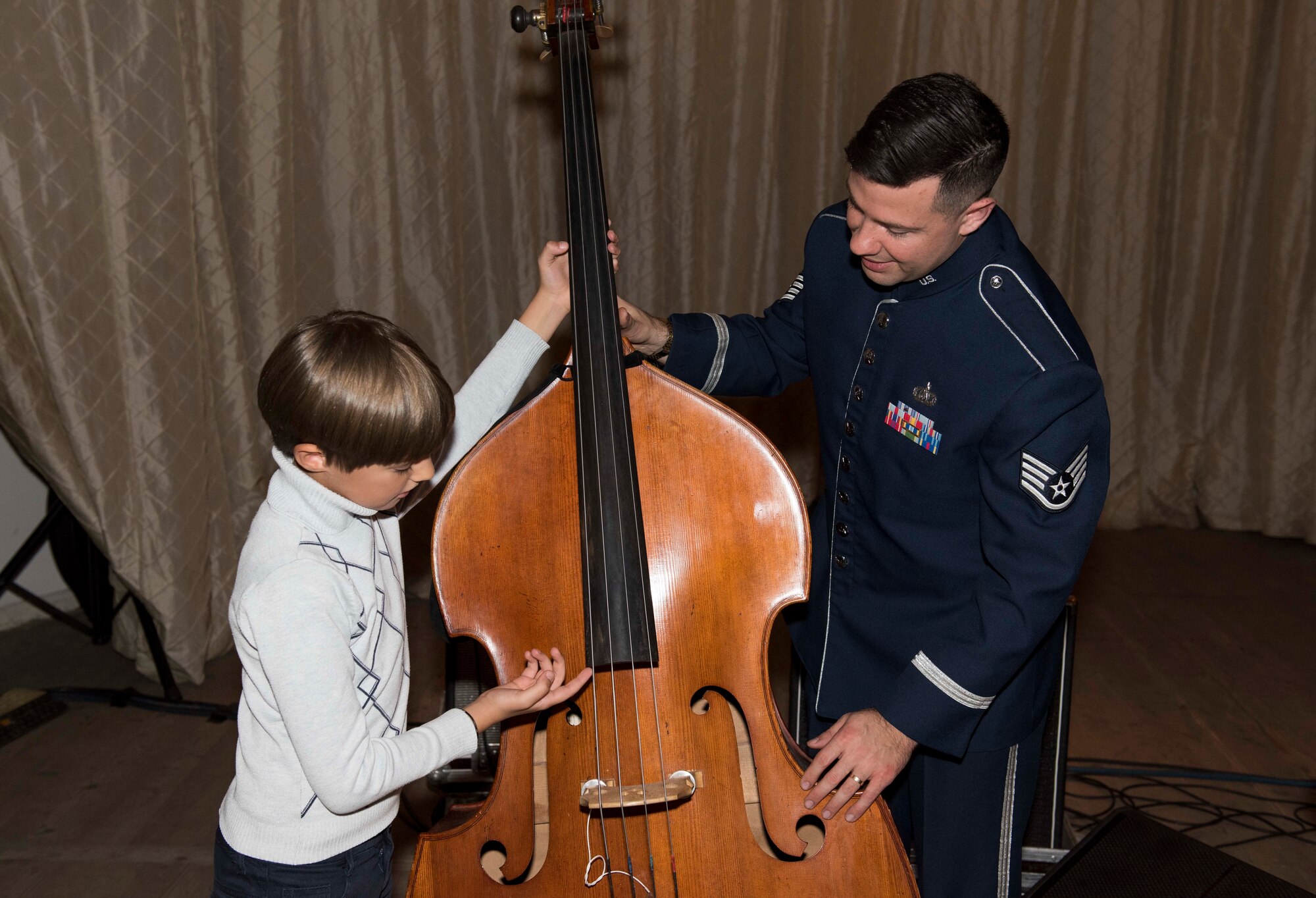 U.S. Air Force Staff Sgt. Benjamin Thomas, U.S. Air Forces in Europe Ambassadors Jazz Band bass player, talks with a local music student about needing to grow a little before being able to play the bass, during a master class with the USAFE Band and the Ukrainian National Presidential Orchestra at the Philharmonic in Chernivisti, Ukraine, Oct. 12, 2019. The USAFE Band traveled to six cities in central and western Ukraine October 6-20, 2019 to conduct the “Music of Freedom” tour, which celebrated the shared spirit of freedom and enduring partnership between U.S. and Ukrainian armed forces. (U.S. Air Force photo by Airman 1st Class Jennifer Zima)