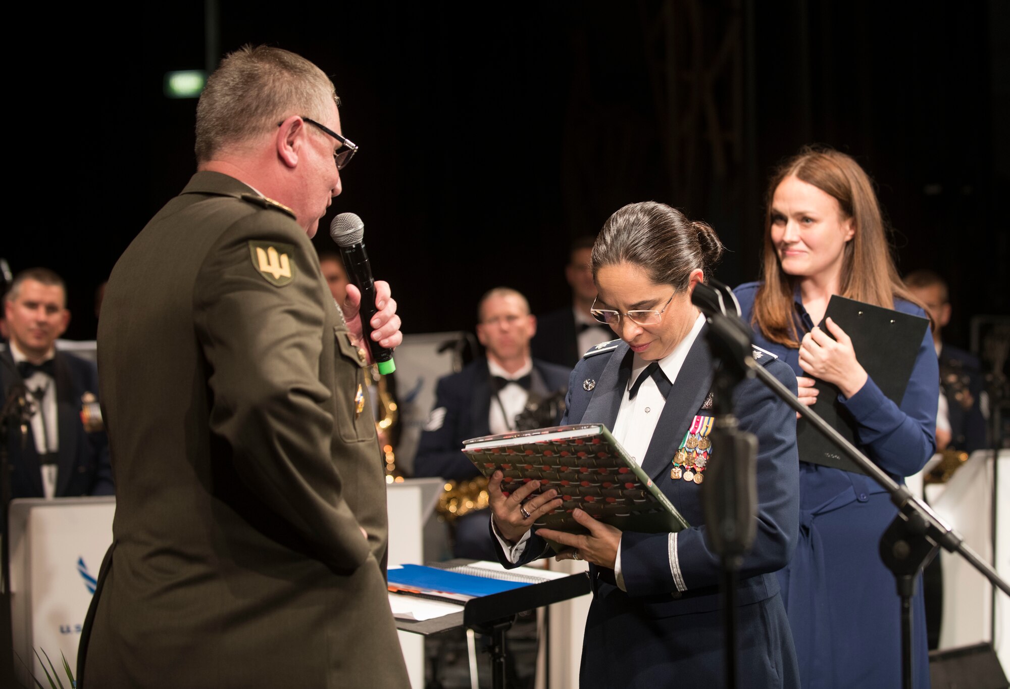 U.S. Air Force Lt. Col Cristina Moore Urrutia, U.S. Air Forces in Europe Ambassadors Jazz Band commander and conductor, accepts a gift from National Ground Forces of Ukraine Lt. Gen. Pavlo Tkachuk, Chief of L’viv Garrison, after the USAFE Band performed a concert with the L’viv Opera Chamber Orchestra and Ukrainian National Presidential Orchestra at the Lviv National Opera, Lviv, Ukraine, October 9, 2019. The USAFE Band traveled to six cities in central and western Ukraine October 6-20, 2019 to conduct the “Music of Freedom” tour, which celebrated the shared spirit of freedom and enduring partnership between U.S. and Ukrainian armed forces. (U.S. Air Force photo by Airman 1st Class Jennifer Zima)