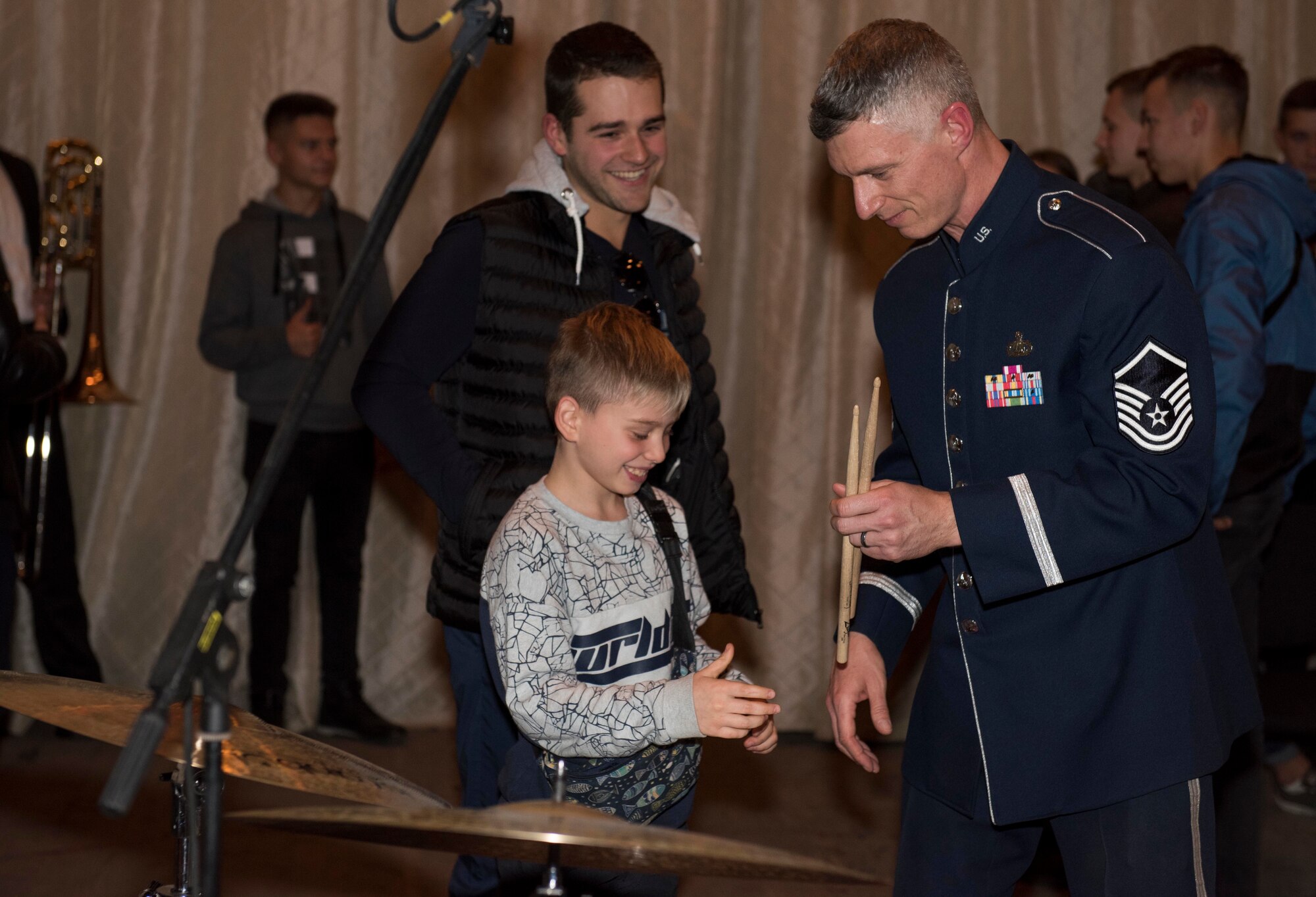 U.S. Air Force Master Sgt. Tim Stombaugh, U.S. Air Forces in Europe Ambassadors Jazz Band drummer, hands drum sticks to a local music student during a master class with the USAFE Band and the Ukrainian National Presidential Orchestra at the Philharmonic in Chernivisti, Ukraine, Oct. 12, 2019. The USAFE Band traveled to six cities in central and western Ukraine October 6-20, 2019 to conduct the “Music of Freedom” tour, which celebrated the shared spirit of freedom and enduring partnership between U.S. and Ukrainian armed forces. (U.S. Air Force photo by Airman 1st Class Jennifer Zima)