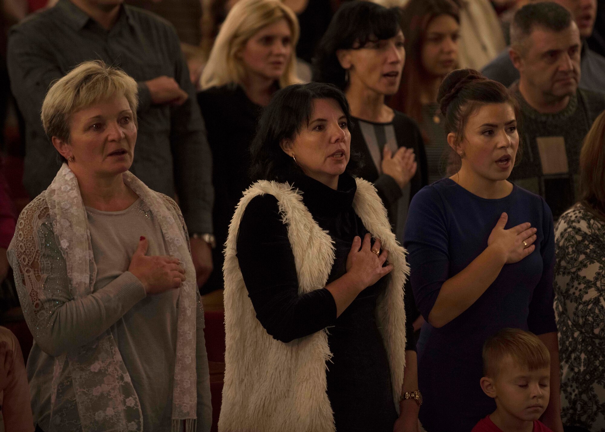 Ukrainian concertgoers honor the playing of the Ukrainian national anthem, “Ще не вмерла України,” during a concert with the U.S. Air Forces in Europe Ambassadors Jazz Band, L’viv Opera Chamber Orchestra and Ukrainian National Presidential Orchestra at the Lviv National Opera, Lviv, Ukraine, October 9, 2019. The USAFE Band traveled to six cities in central and western Ukraine October 6-20, 2019 to conduct the “Music of Freedom” tour, which celebrated the shared spirit of freedom and enduring partnership between U.S. and Ukrainian armed forces. (U.S. Air Force photo by Airman 1st Class Jennifer Zima)