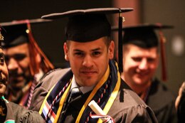 Staff Sgt. Noel Gerig, 1st Theater Sustainment Command, strikes a pose during the Fort Knox Army Education Center College Graduation Ceremony at Waybur Theater, Oct, 17, 2019 on Fort Knox, Ky.