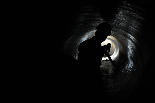 Maj. Michael Knauf looks on as Dusty Pickens sweeps water in raw water pipes near the Engine Test Facility J-3 test cell at Arnold Air Force Base during a Sept. 23 inspection of pipes recently lined with a fiber-reinforced polymer. (U.S. Air Force photo by Bradley Hicks)
