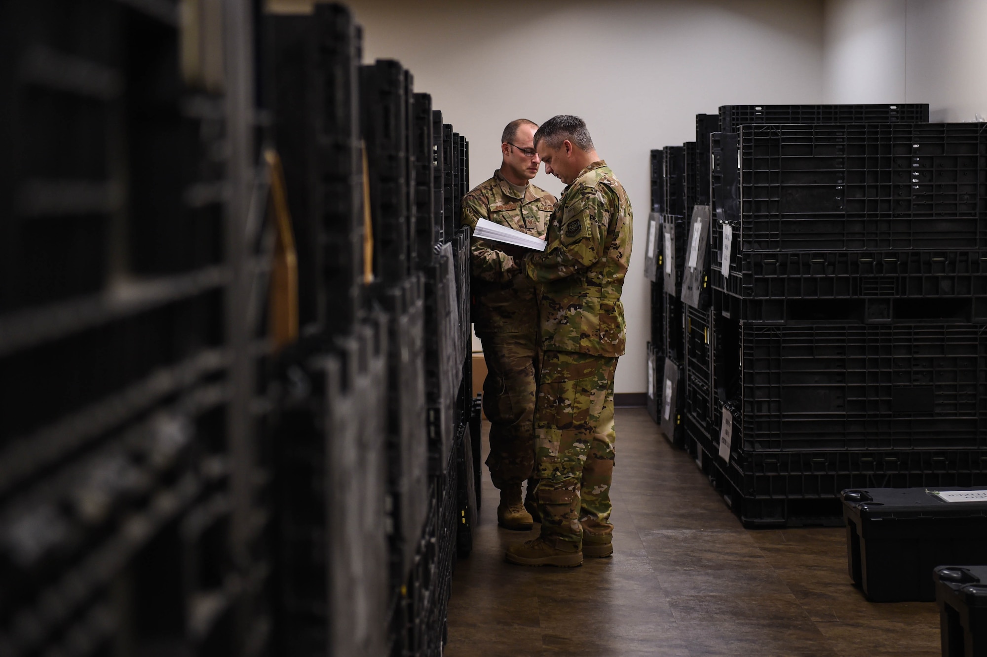 Tech. Sgt. Ryan Pappas, 62nd Aerial Port Squadron air transportation standardization evaluation program evaluator, and Col. Robert Lankford, 62nd Operations Group commander, peruse the in-processing room at the Pfingston Reception Center at Lackland Air Force Base, Texas, Oct. 17, 2019. When new U.S. Air Force basic military trainees arrive at Lackland they go through the in-processing room where they are issued backpacks containing what they need for basic military training.