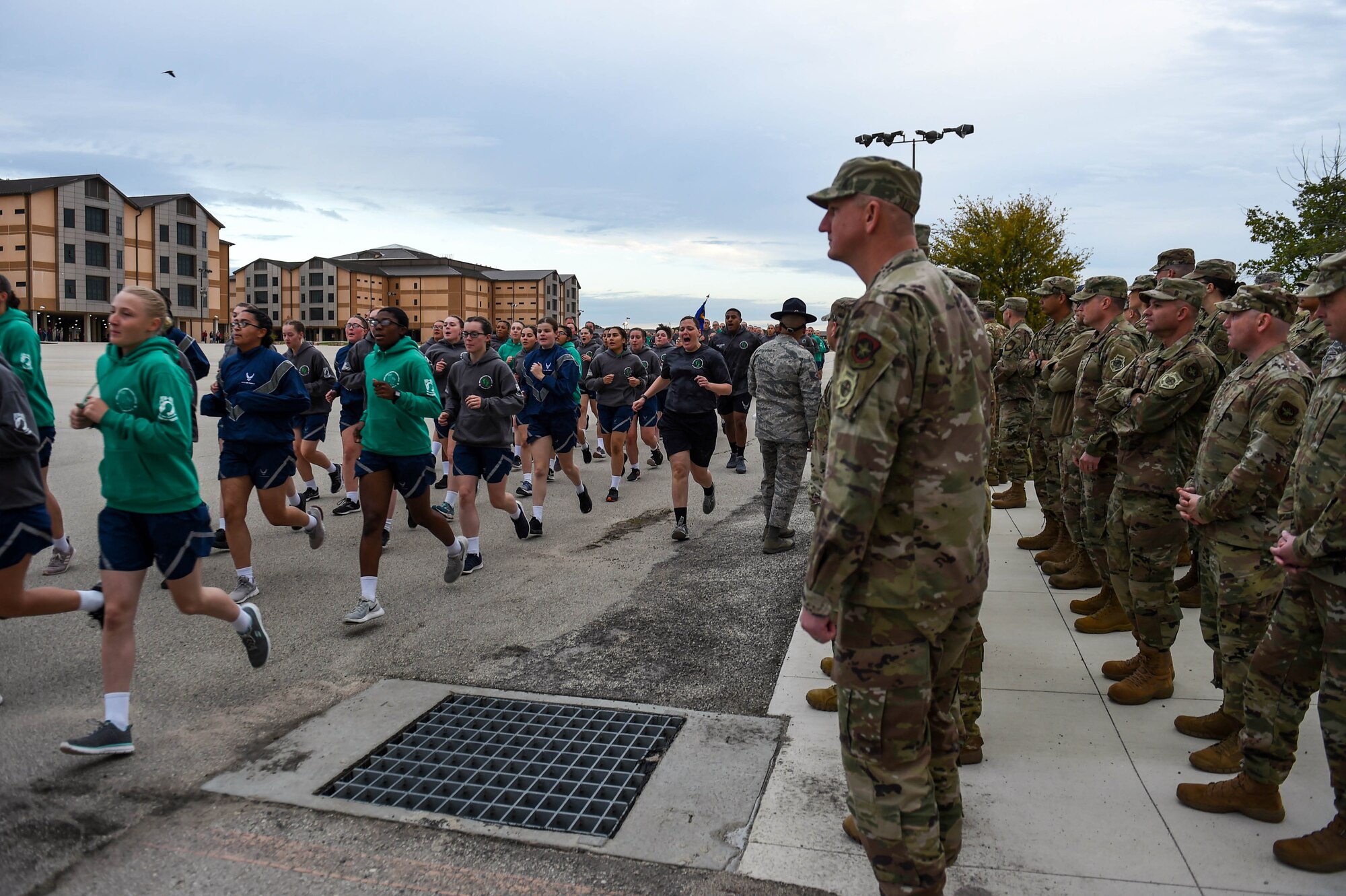 U.S. Air Force Basic Military trainees participate in the Airmen’s Run while Chief Master Sgt. John Lipsey, center right, 62nd Maintenance Group command chief, and other leadership members from the 62nd Airlift Wing, Joint Base Lewis-McChord, Wash., watch the run Oct. 17, 2019. The Airmen’s Run is one of the graduation events that all Basic Military Training flights participate in. It occurs on the main drill pad where families and friends of graduating trainees can cheer and spectate.