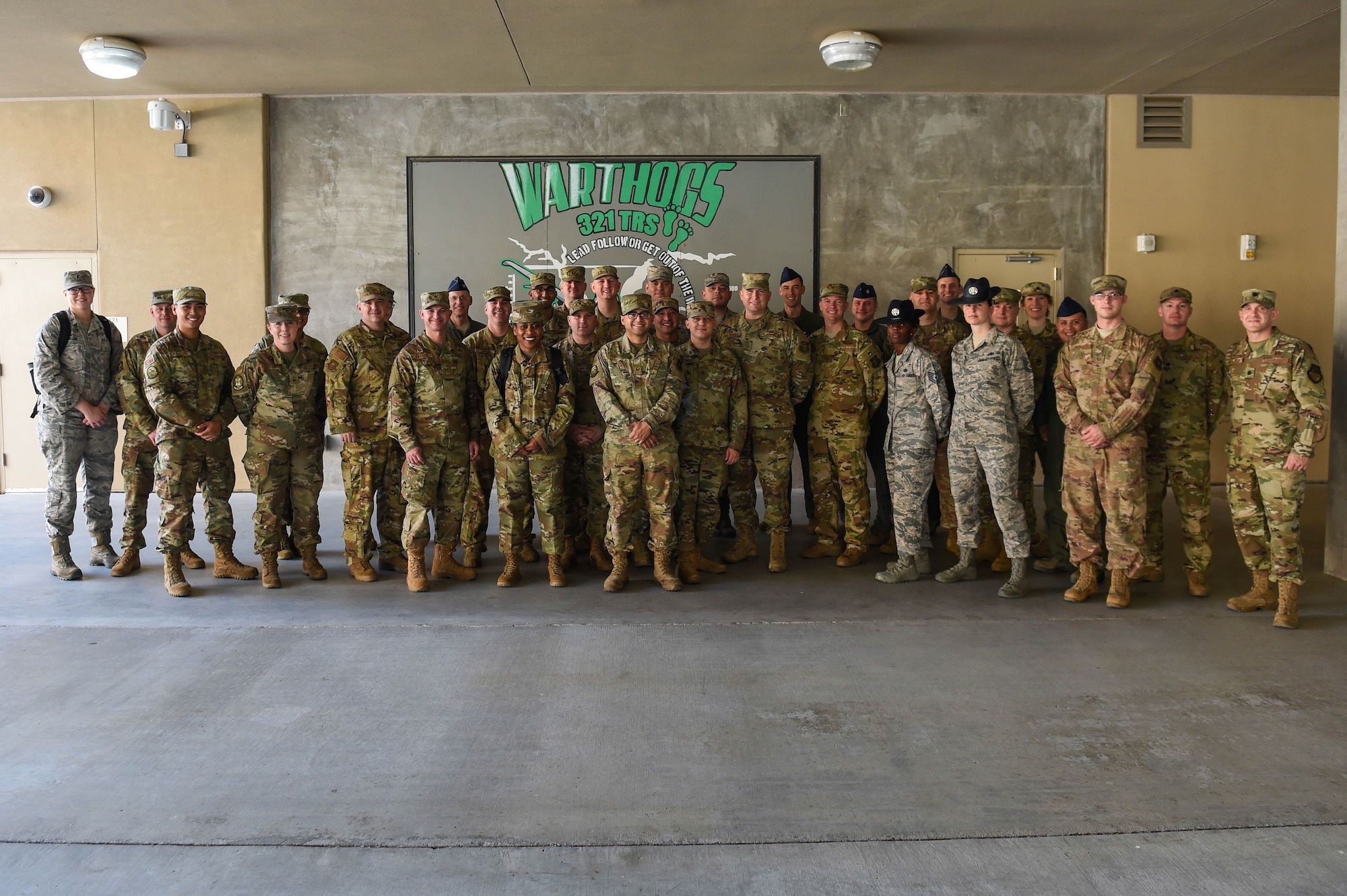 A group of leadership members from the 62nd Airlift Wing, Joint Base Lewis-McChord, Wash., pose for a photo with Tech. Sgt. Kendra Bossard and Tech. Sgt. Christina Soto, 321st Training Squadron (321 TRS) military training instructors, front row, 3rd and 2nd from right, at the 321 TRS at Lackland Air Force Base, Texas, Oct. 17, 2019. Military training instructors (MTI) have to be nominated for the position before submitting a two-part application, undergoing a mental health screening, and if selected, they have at least eight weeks of job training before they have their own flight of basic trainees.