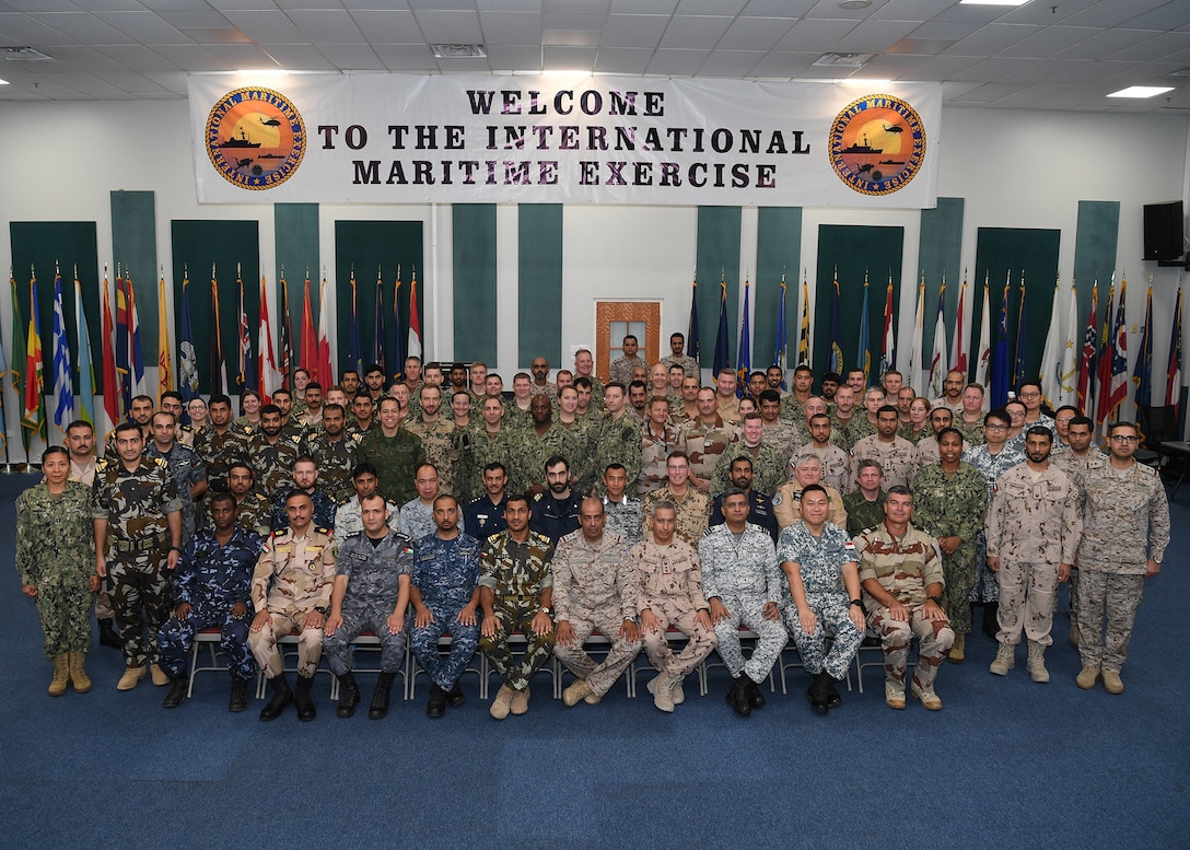 191021-N-KZ419-1074 NAVAL SUPPORT ACTIVITY BAHRAIN, Bahrain (Oct. 21, 2019) International Maritime Exercise (IMX) 2019 staff members pose for a photo during the opening ceremony of IMX 2019. IMX 2019 is a multinational engagement involving partners and allies from around the world sharing knowledge and experiences across the full spectrum of defensive maritime operations. The exercise serves to demonstrate global resolve in maintaining regional security and stability, freedom of navigation and the free flow of commerce from the Suez Canal south to the Bab-el-Mandeb through the Strait of Hormuz to the Northern Arabian Gulf. (U.S. Navy photo by Mass Communication Specialist 3rd Class Dawson Roth/Released)