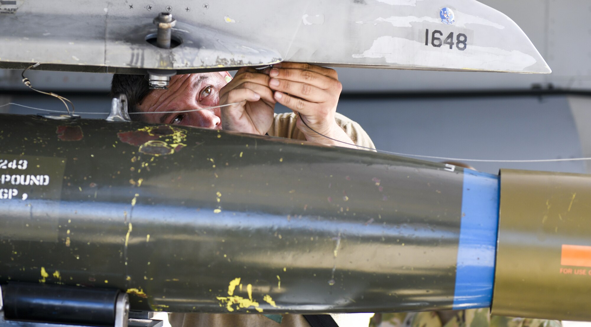 Staff Sgt. Matthew Perry, 309th Aircraft Maintenance Unit weapons load crew team chief, attaches an inert bomb on to an F-16C Fighting Falcon during the 3rd Quarter Load Crew Competition Oct. 17, 2019, at Luke Air Force Base, Ariz.