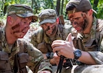 Air Force Capt. Logan Hawke, a pilot assigned to the 16th Airlift Squadron; Master Sgt. William Davis and Staff Sgt. Randall Moss, loadmasters assigned to the 16th Airlift Squadron, communicate with rescue forces with a radio during a survival, evasion, resistance, and escape exercise in North, South Carolina, Aug. 21. SERE specialists assigned to the 437th Operations Support Squadron conducted this exercise in order to identify potential areas of improvement in both SERE training and equipment provided to aircrew in case of a potential isolating event.