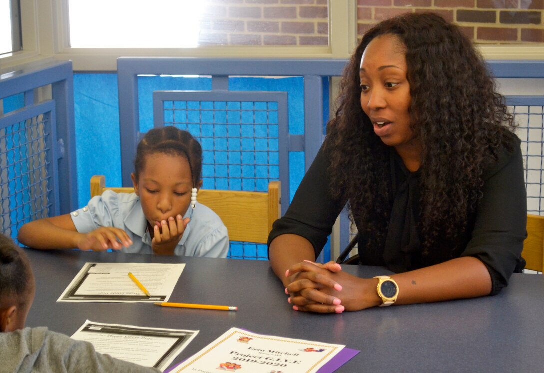 Monique Porter, a DLA Troop Support Project G.I.V.E. tutor, helps students with schoolwork during the initial Project G.I.V.E. tutoring session for the 2019-2020 school year at the Benjamin Franklin Elementary School Oct. 15, 2019 in Philadelphia.