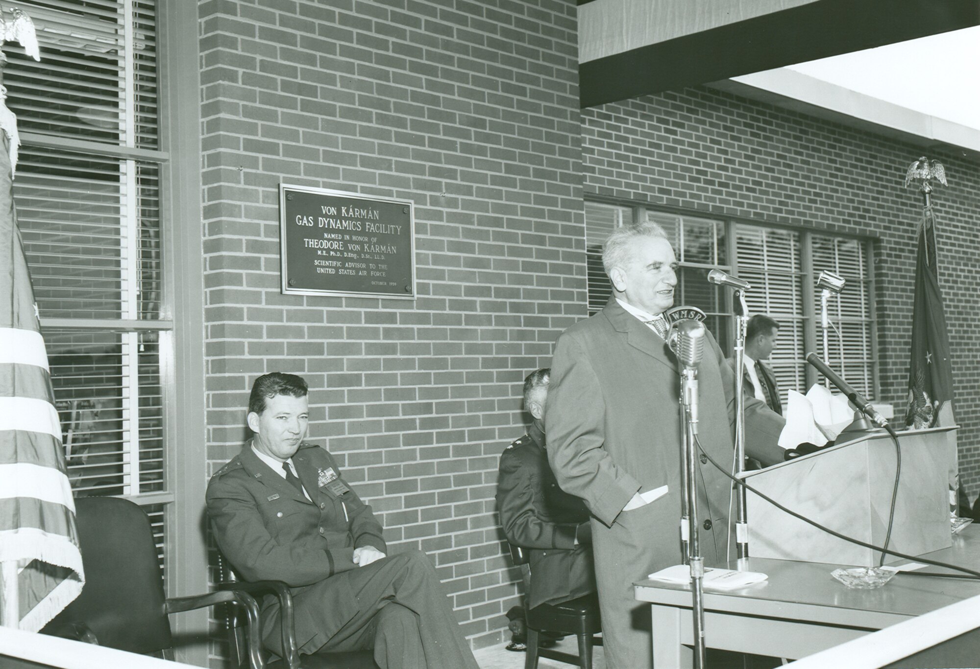 Dr. Theodore von Kármán speaks during the Oct. 30, 1959, ceremony to dedicate the Gas Dynamics Facility at Arnold Air Force Base in his honor. Von Kármán helped provide the blueprint that led to the construction of Arnold Engineering Development Complex at Arnold AFB. Seated behind von Kármán is Gen. Bernard Schriever, then-commander of Air Force Systems. (U.S. Air Force photo)