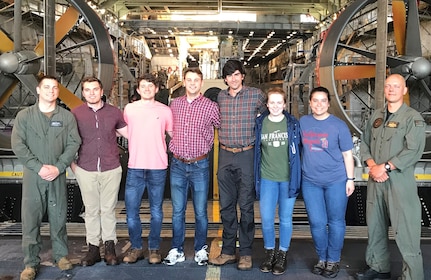 IMAGE: USS CARTER HALL (April 30, 2019) – Six members of the Naval Surface Warfare Center Dahlgren Division (NSWCDD) Sly Fox Mission 26 team are pictured with Sailors in front of a Landing Craft Air Cushion vehicle aboard USS CARTER HALL (LSD 50). Over the course of a one-week deployment, the Sly Fox Mission 26 team collaborated with the Carter Hall crew while studying operations throughout the ship to develop a system called PERSEUS that lays the groundwork for solving power management in the future Navy.  (U.S. Navy photo/Released)