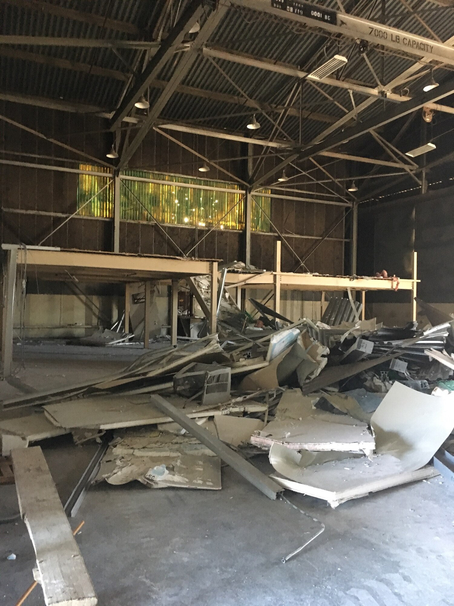 Debris from dismantled structures cover the floor of Building 844 at Travis Air Force Base, California, July 2, 2019. The refurbished hangar houses the new Nose Dock Gym, facilitated through existing base funds, equipment donations and volunteer work by the 60th Mission Support Group. (U.S. Air Force courtesy photo)