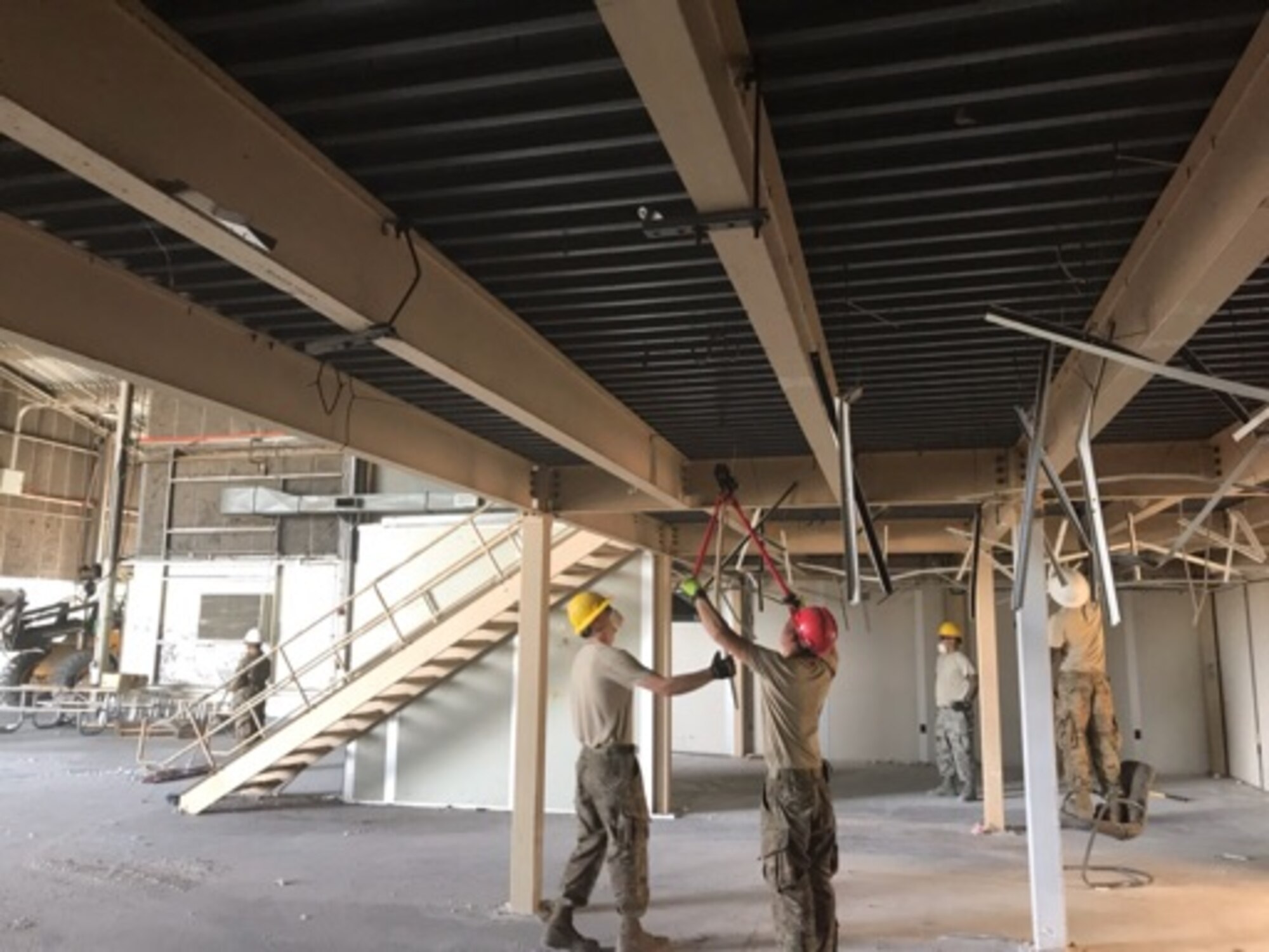 Crews from the 60th Civil Engineer Squadron structures shop dismantle old mobile offices inside Building 844 at Travis Air Force Base, California, July 2, 2019. The refurbished hangar houses the new Nose Dock Gym, facilitated through existing base funds, equipment donations and volunteer work by the 60th Mission Support Group. (U.S. Air Force courtesy photo)