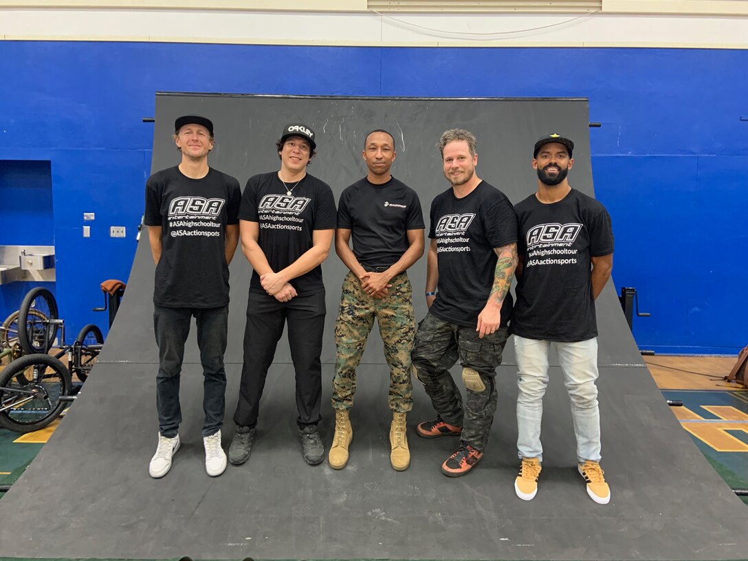 U.S. Marine Corps Staff Sgt. Glendon Gopaul, a canvassing recruiter with Recruiting Station San Diego, stands next to world-class BMX athletes at San Diego High School, April 8, 2019. The Action Sports Tour communicated an anti-bullying message throughout schools in San Diego. (U.S. Marine Corps photo by Sgt. Bernadette Plouffe)