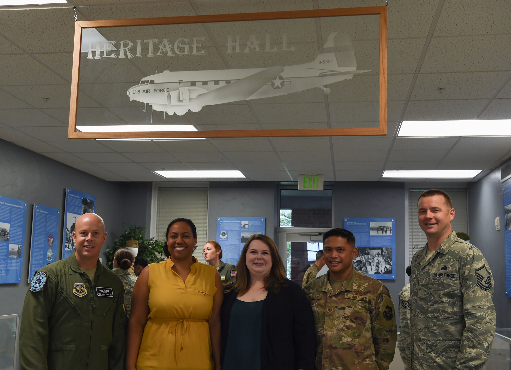 Erin Lasley, middle, 62nd Airlift Wing historian, and her team pose for a photo after a ribbon cutting ceremony opening the new Heritage Hall in the wing headquarters building at Joint Base Lewis-McChord, Wash., Oct. 21, 2019. Lasley and her team updated the hall to showcase Team McChord’s heritage. (U.S. Air Force photo by Senior Airman Tryphena Mayhugh)